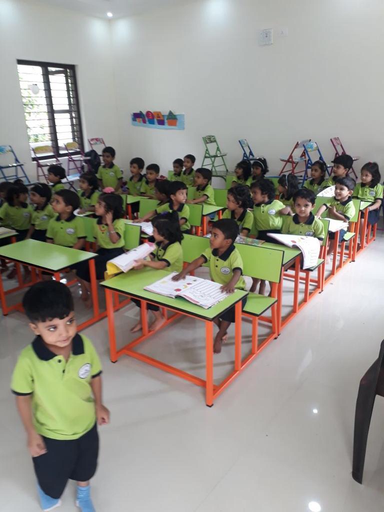 Childrens sitting in the Classroom desks and benches